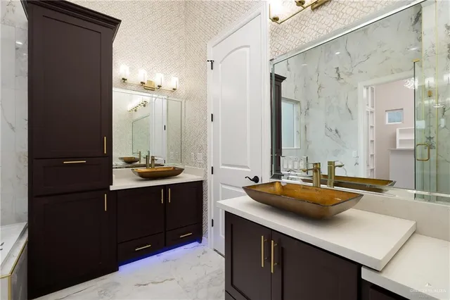 a bathroom with a sink double vanity granite tub shower and a mirror