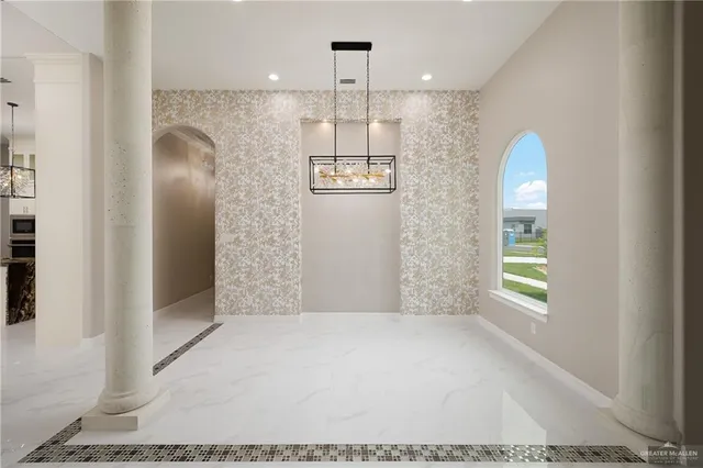 a view of a hallway with windows and chandelier