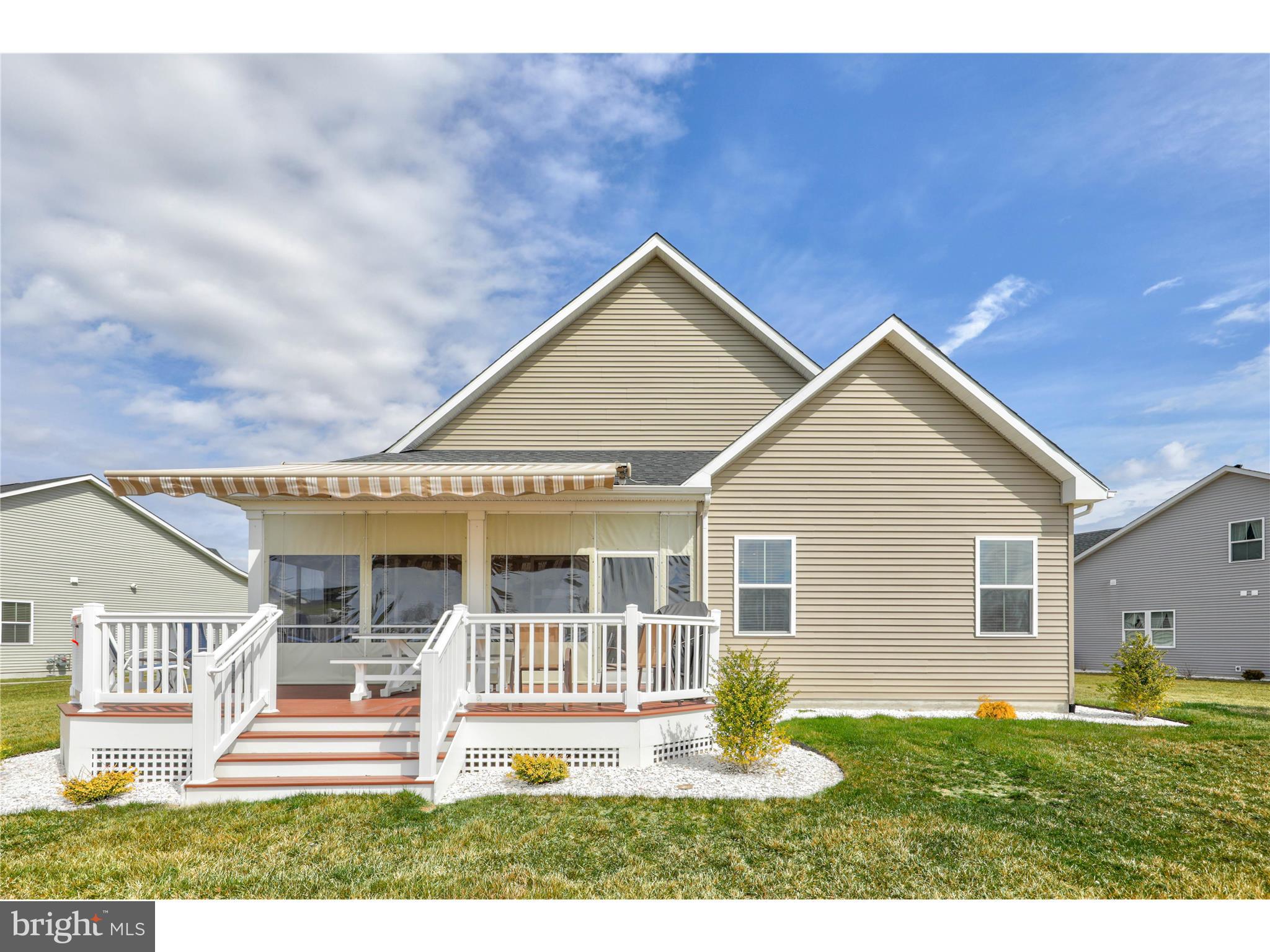 Back of house with extendable awning and sunroom