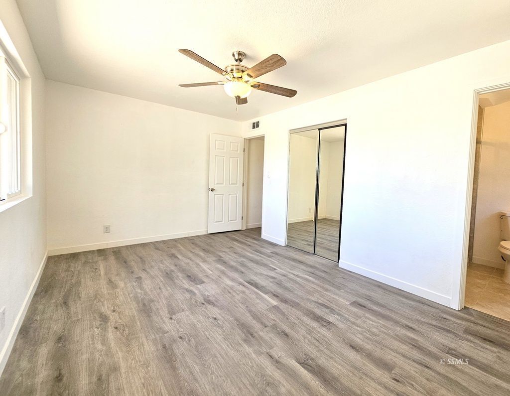 247 West Perdew Avenue Ridgecrest, CA 93555 - Photo 13 of 24 an empty room with wooden floor fan and windows