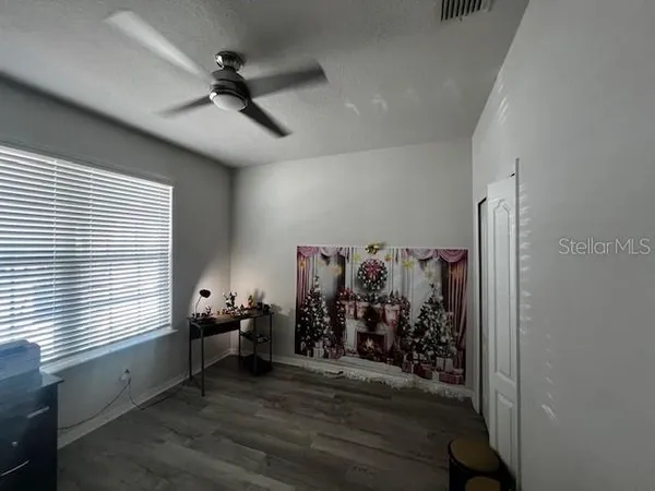 a view of a livingroom with a window and wooden floor