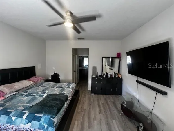a bedroom with a bed and a flat tv screen on dresser