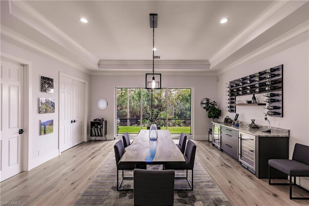 20199 Markward Crossing Estero, FL 33928 - Photo 12 of 45 a dining room with furniture a chandelier and wooden floor