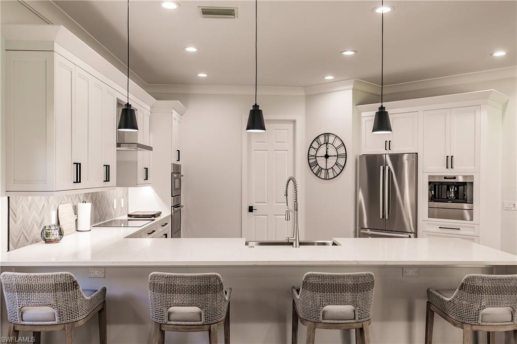 20199 Markward Crossing Estero, FL 33928 - Photo 7 of 45 a kitchen with stainless steel appliances granite countertop a sink and a refrigerator