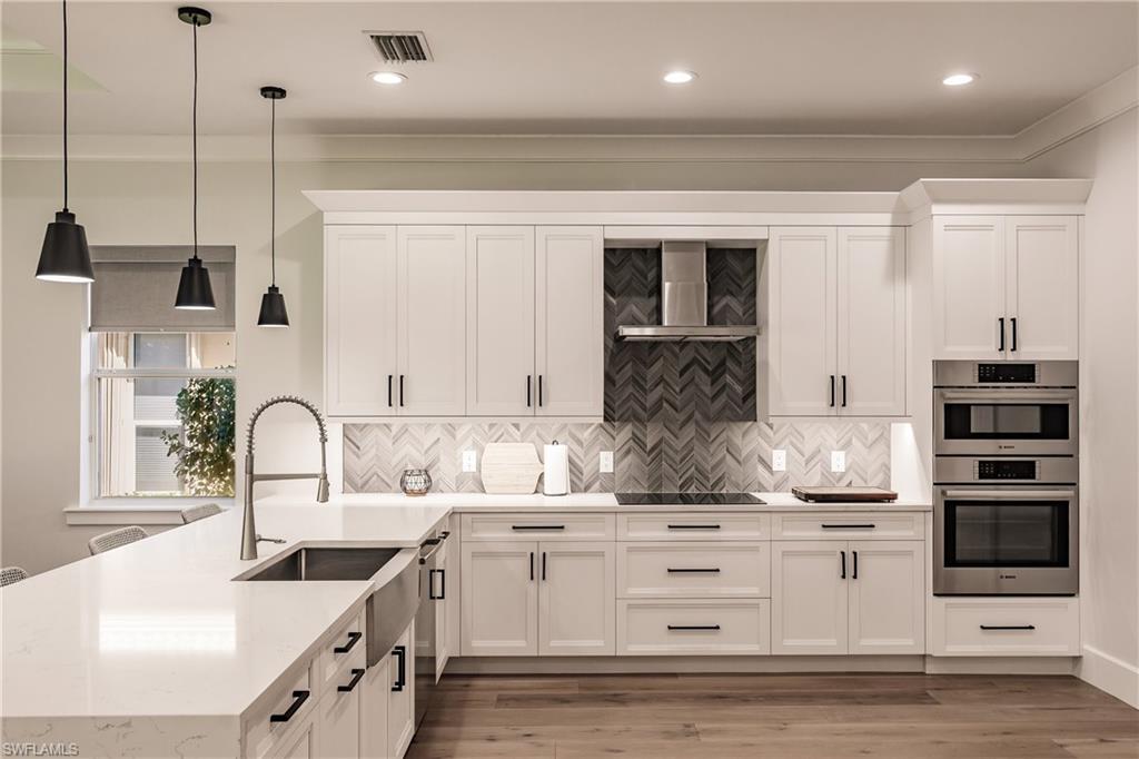 20199 Markward Crossing Estero, FL 33928 - Photo 9 of 45 a kitchen with kitchen island granite countertop a sink a counter space appliances and cabinets