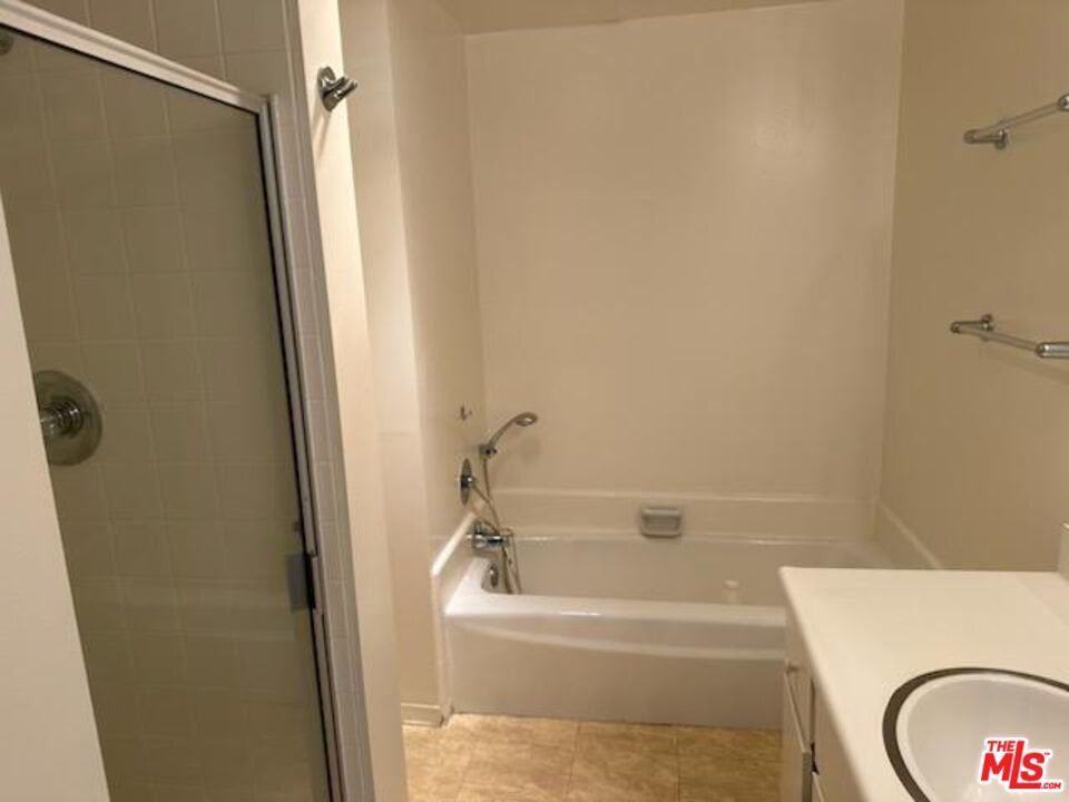 2160 Century Park East, Unit 503 Los Angeles, CA 90067 - Photo 10 of 22 a bathroom with a granite countertop sink toilet and shower
