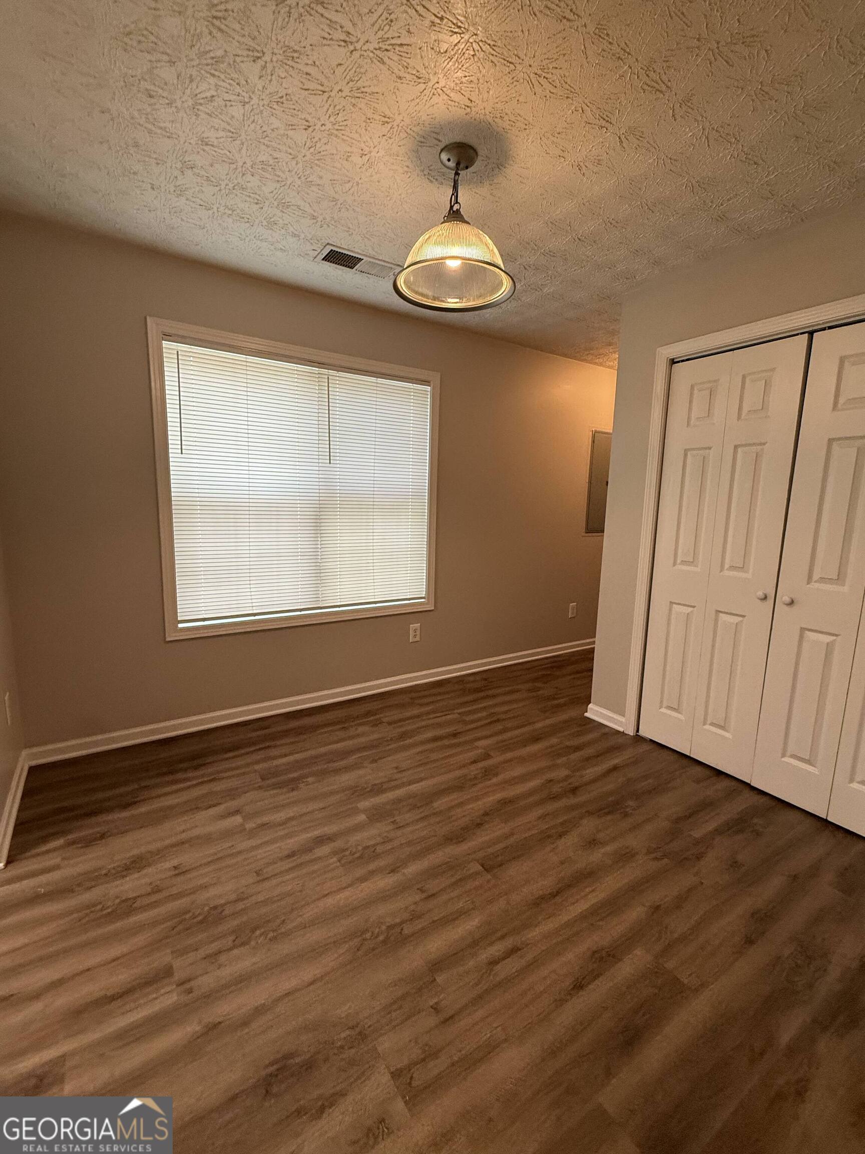 6132 Ruth Street Southwest Covington, GA 30014 - Photo 28 of 33 an empty room with wooden floor chandelier and windows
