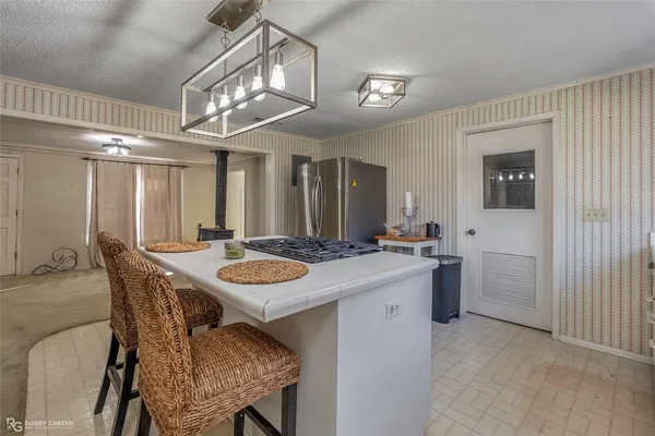 a dining room with a table chairs and a kitchen view