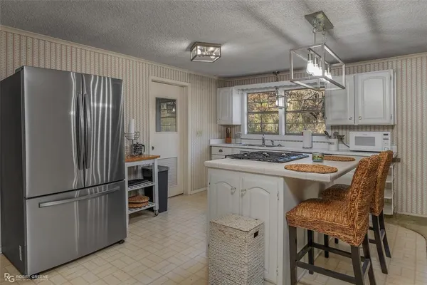 a kitchen with refrigerator cabinets and chairs