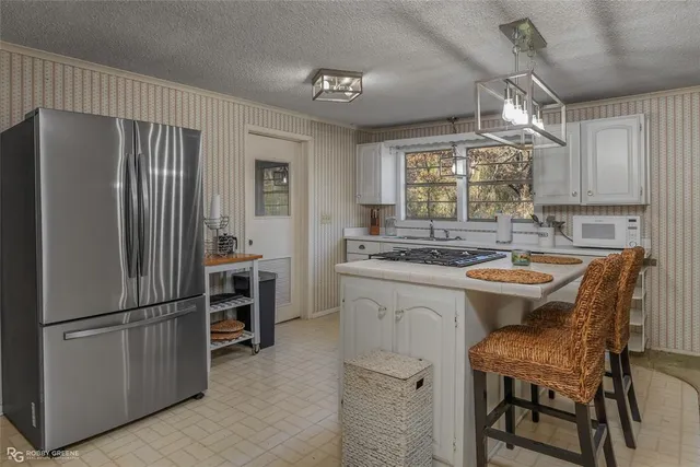 a kitchen with refrigerator cabinets and chairs