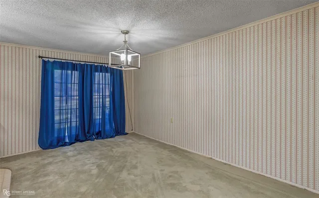 an empty room with chandelier fan