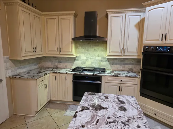 a kitchen with stainless steel appliances granite countertop a stove a sink and a microwave