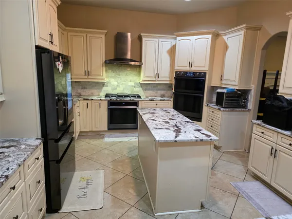 a kitchen with a sink a stove top oven a refrigerator and cabinets