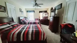 a bedroom with a bed window and a flat screen tv