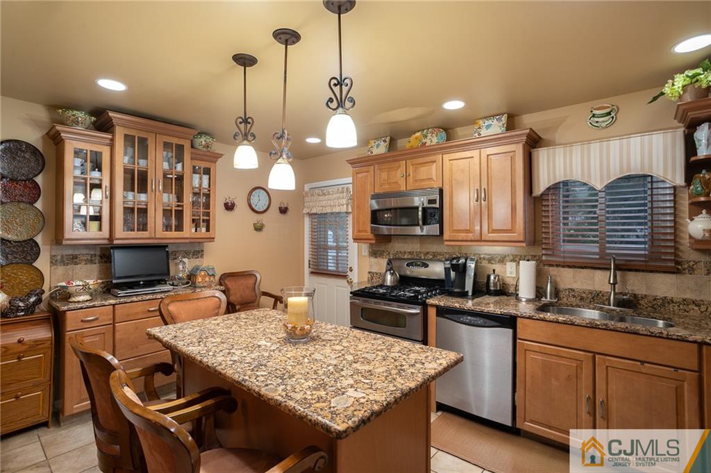 460 Warfield Road North Plainfield, NJ 07060 - Photo 11 of 29 a kitchen with granite countertop a stove a sink dishwasher a dining table and chairs with wooden floor