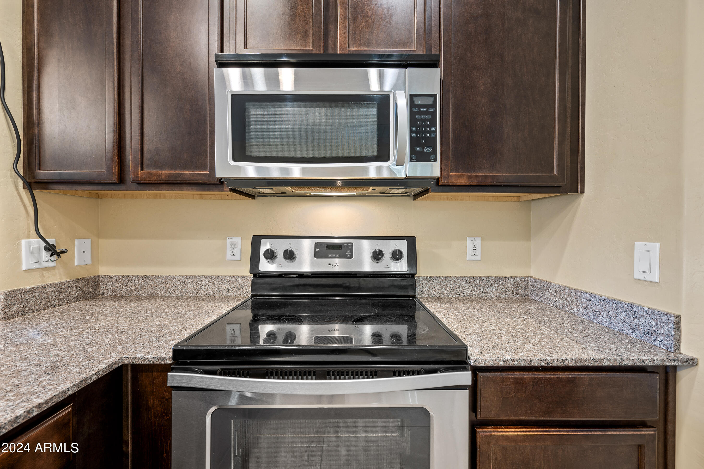 7726 East Baseline Road, Unit 235 Mesa, AZ 85209 - Photo 8 of 31 a kitchen with granite countertop a stove top oven microwave and cabinets