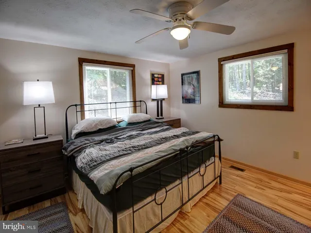 a bedroom with a bed and a lamp on dresser