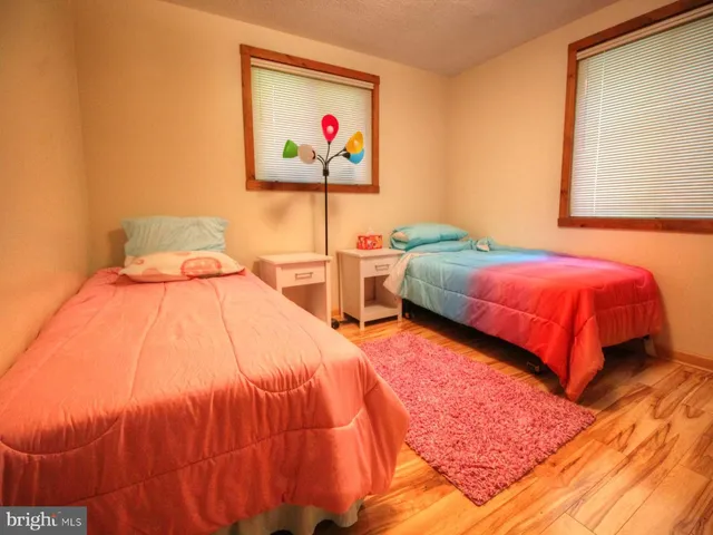 a bedroom with two beds and a painting on the wall