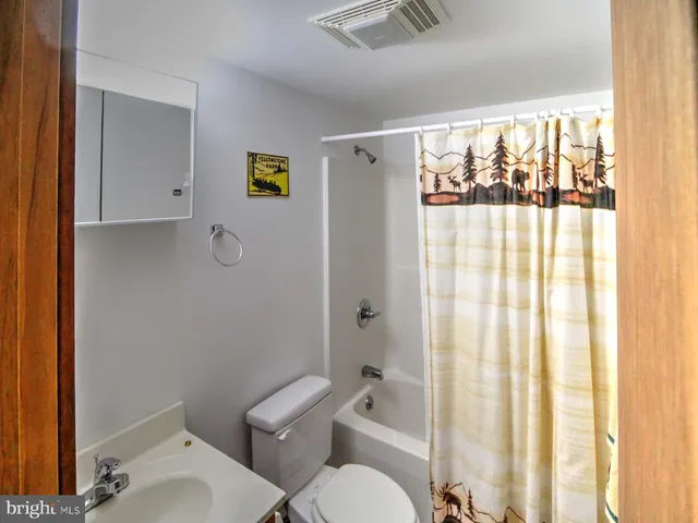 a white toilet sitting next to a bathroom sink and tub