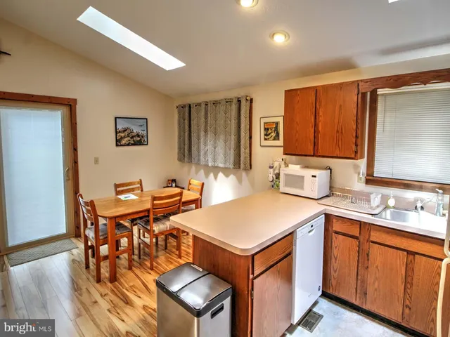 a view of a kitchen area with furniture and wooden floor