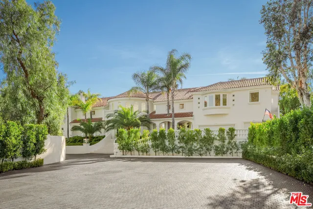 a white house with a yard and plants