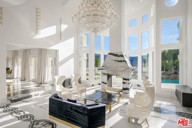 a living room with furniture kitchen view and a wooden floor