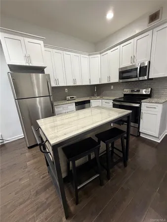 a kitchen with a table chairs sink and cabinets