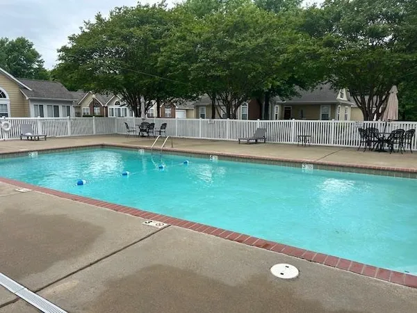 a view of house with swimming pool and a yard
