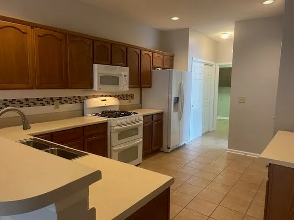 a kitchen with kitchen island a counter top space a sink and stainless steel appliances