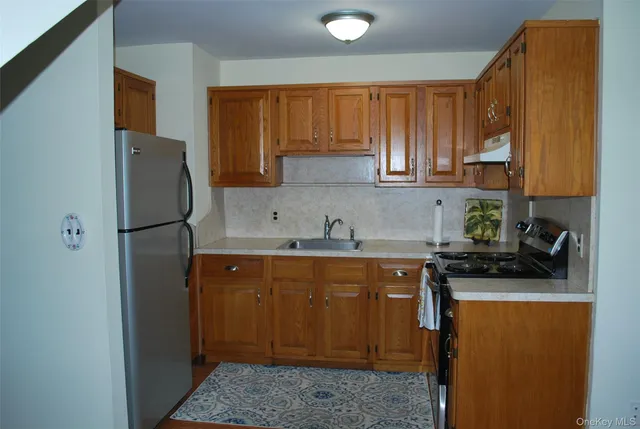 a kitchen with stainless steel appliances granite countertop a refrigerator and a sink