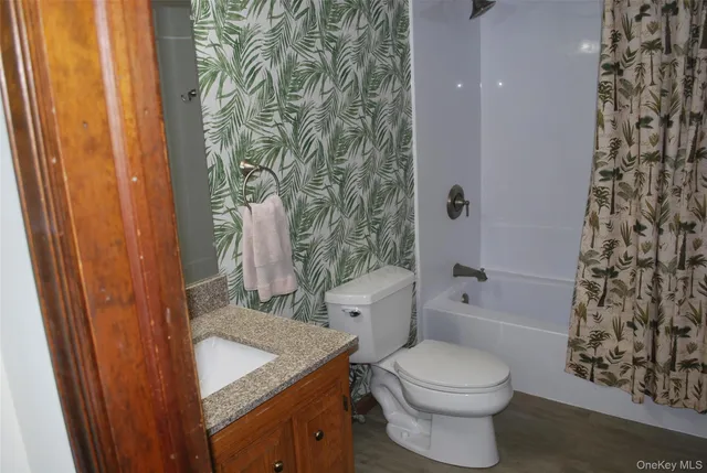 a bathroom with a sink a toilet and shower curtain