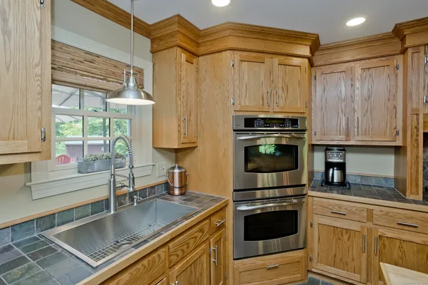 a kitchen with stainless steel appliances granite countertop a stove a sink and a microwave