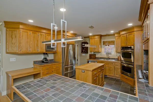 a kitchen with stainless steel appliances a refrigerator sink and stove