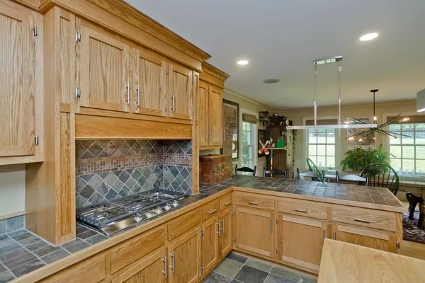 a kitchen with kitchen island granite countertop a sink counter top space appliances and cabinets