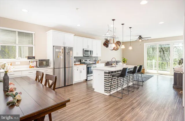 a kitchen with a table chairs refrigerator and window