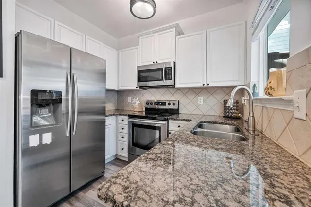 a large bed sitting in a bedroom next to a window and a lamp