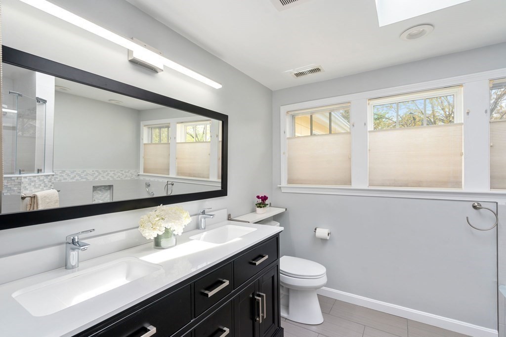 26 William Street Needham, MA 02494 - Photo 24 of 35 a bathroom with a double vanity sink toilet and a mirror