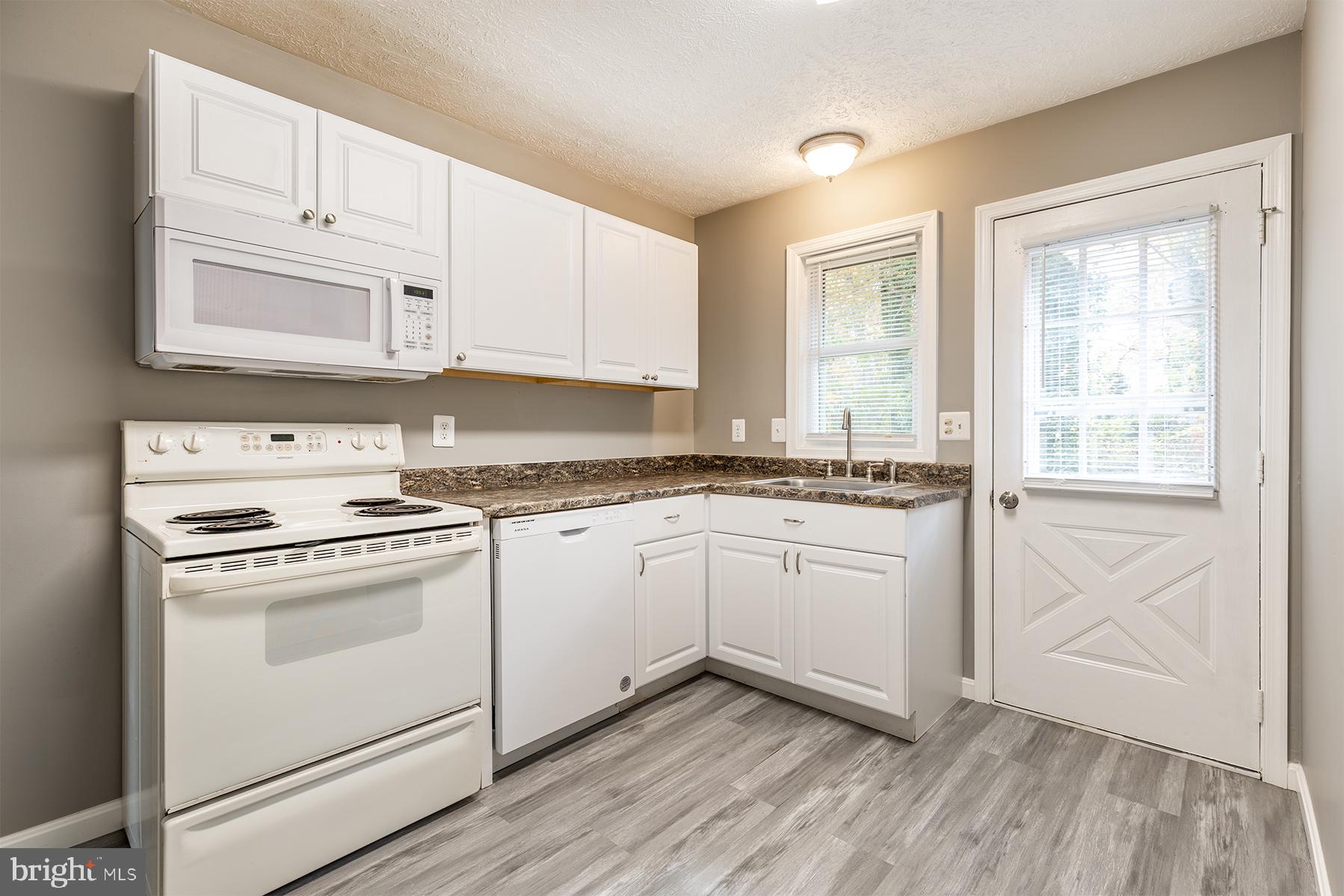 847 Harbor View Terrace Annapolis, MD 21409 - Photo 24 of 42 a kitchen with granite countertop white cabinets and white appliances