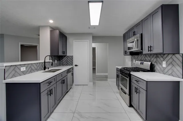 a kitchen with a sink stove and cabinets