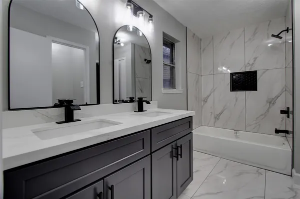 a bathroom with a tub sink and mirror