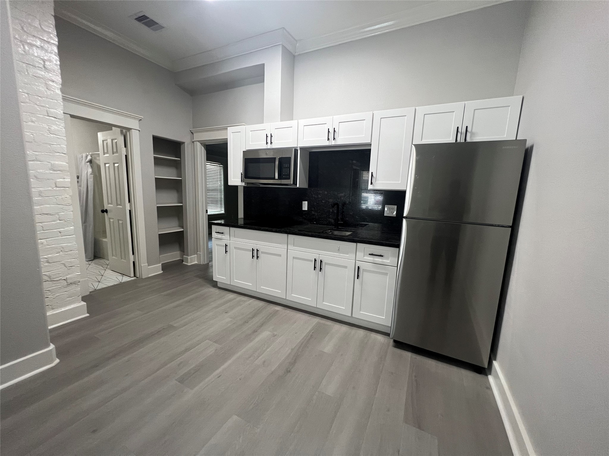 220 Redan Street, Unit A Houston, TX 77009 - Photo 7 of 22 a kitchen with stainless steel appliances a refrigerator and cabinets