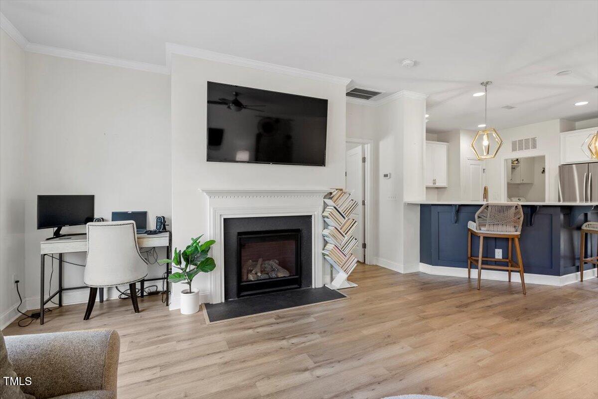 225 Mayfield Drive Apex, NC 27539 - Photo 18 of 41 a living room with furniture a fireplace and a flat screen tv