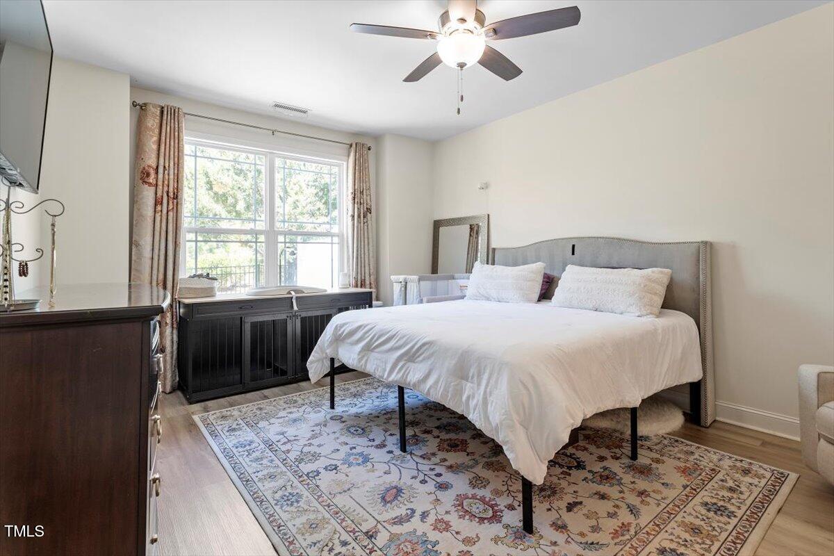 225 Mayfield Drive Apex, NC 27539 - Photo 21 of 41 a spacious bedroom with a bed and a chandelier