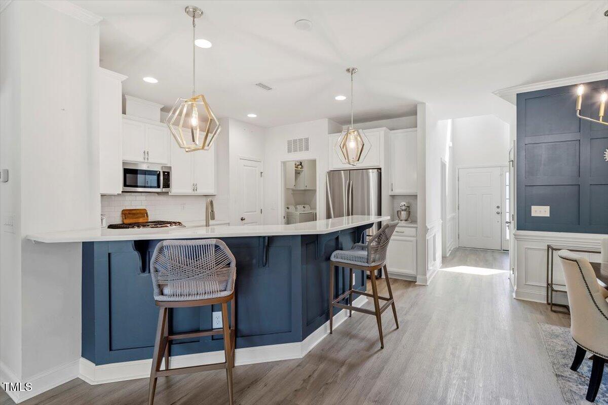 225 Mayfield Drive Apex, NC 27539 - Photo 9 of 41 a kitchen with a table chairs refrigerator and microwave
