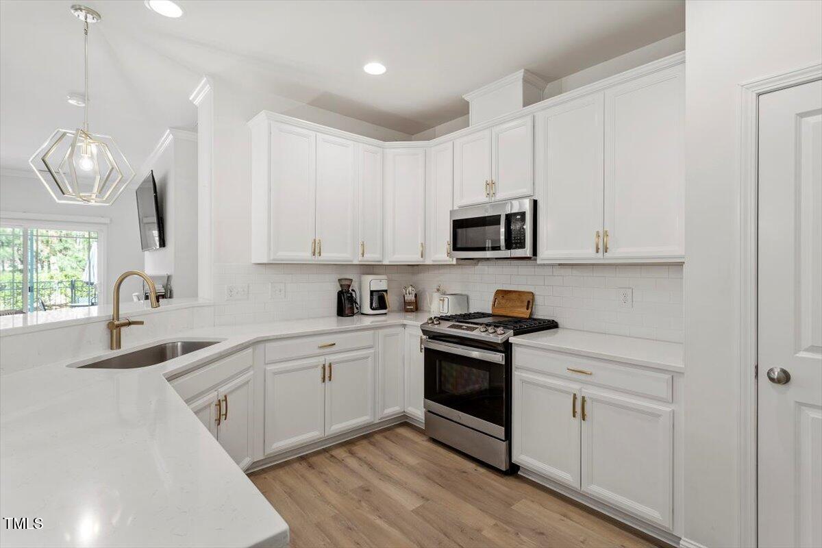 225 Mayfield Drive Apex, NC 27539 - Photo 10 of 41 a kitchen with white cabinets stainless steel appliances and sink