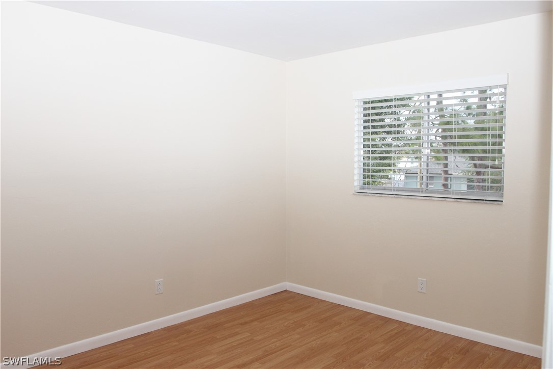 8461 Cardinal Road Fort Myers, FL 33967 - Photo 12 of 19 a view of an empty room with wooden floor and a window