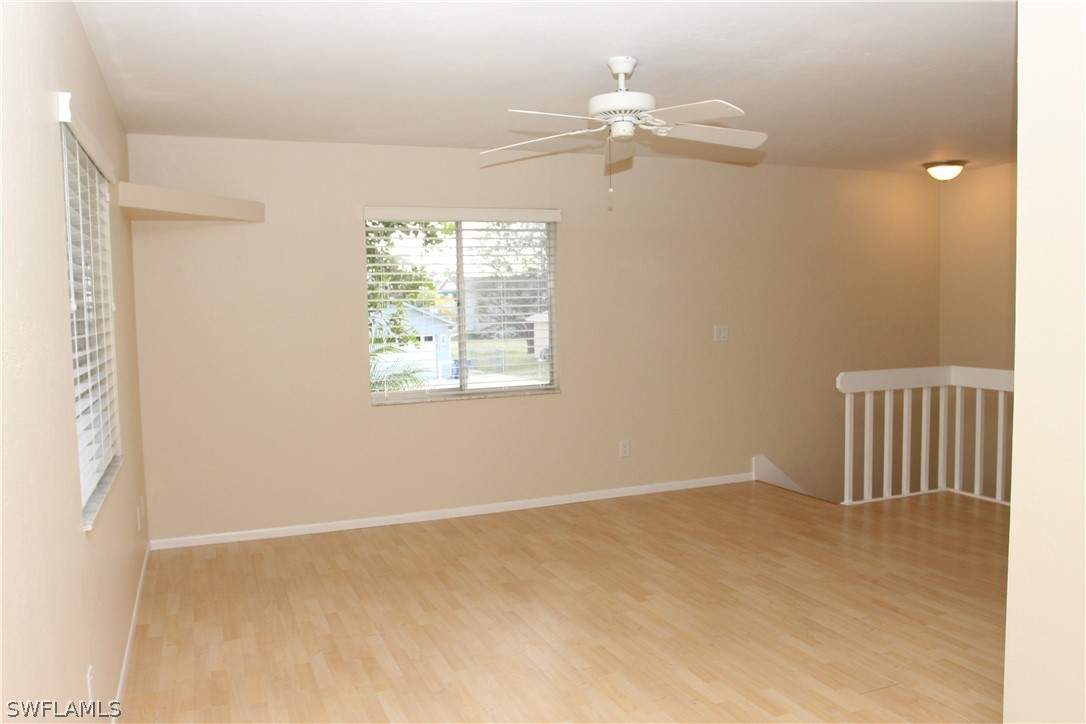 8461 Cardinal Road Fort Myers, FL 33967 - Photo 4 of 19 an empty room with a chandelier fan and windows