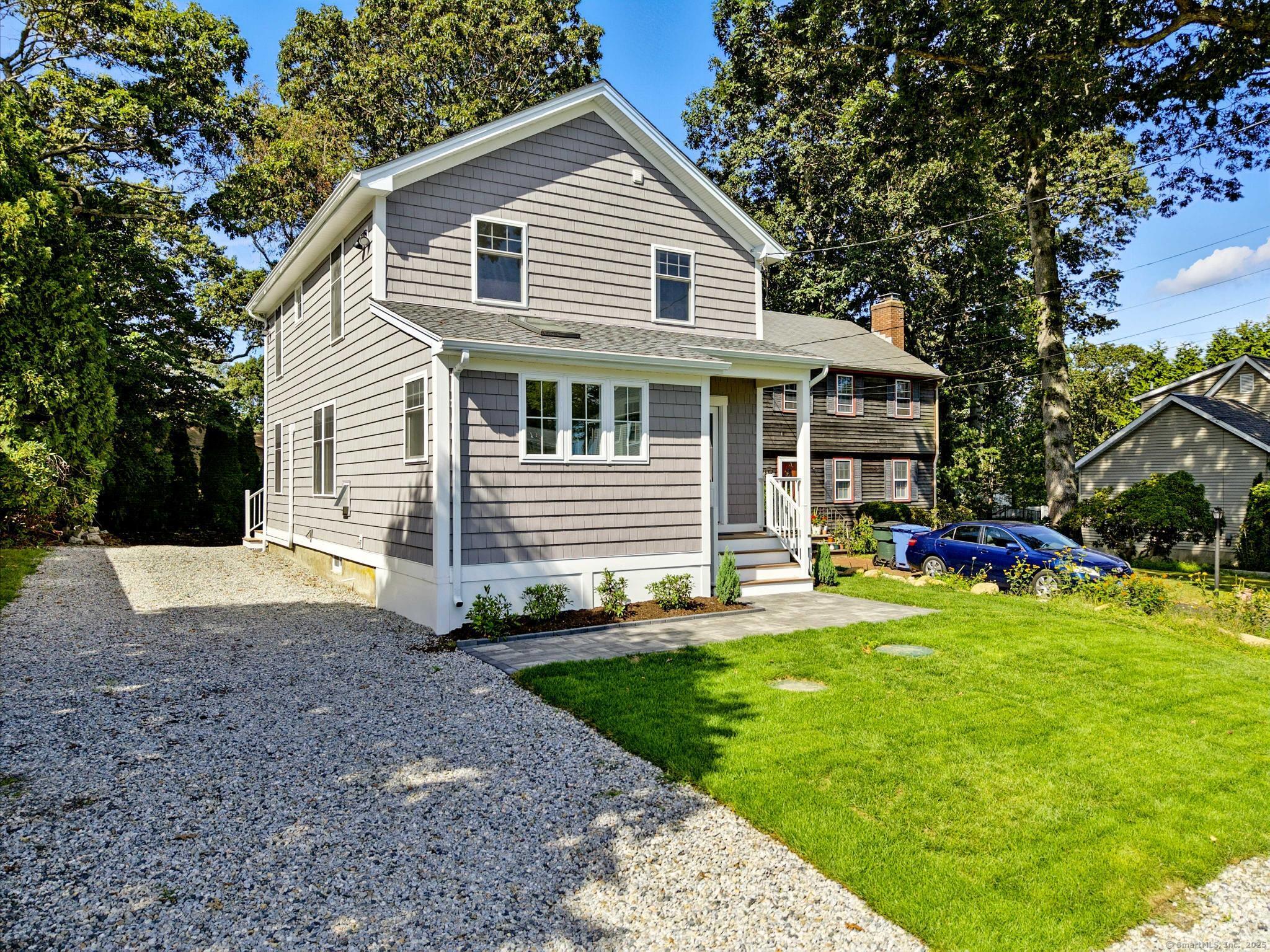 a front view of a house with a yard and trees