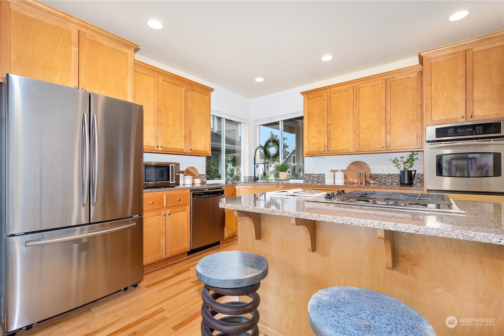 16722 166th Place Southeast Renton, WA 98058 - Photo 13 of 35 a kitchen with stainless steel appliances granite countertop a refrigerator a sink dishwasher a stove with wooden cabinets and floor