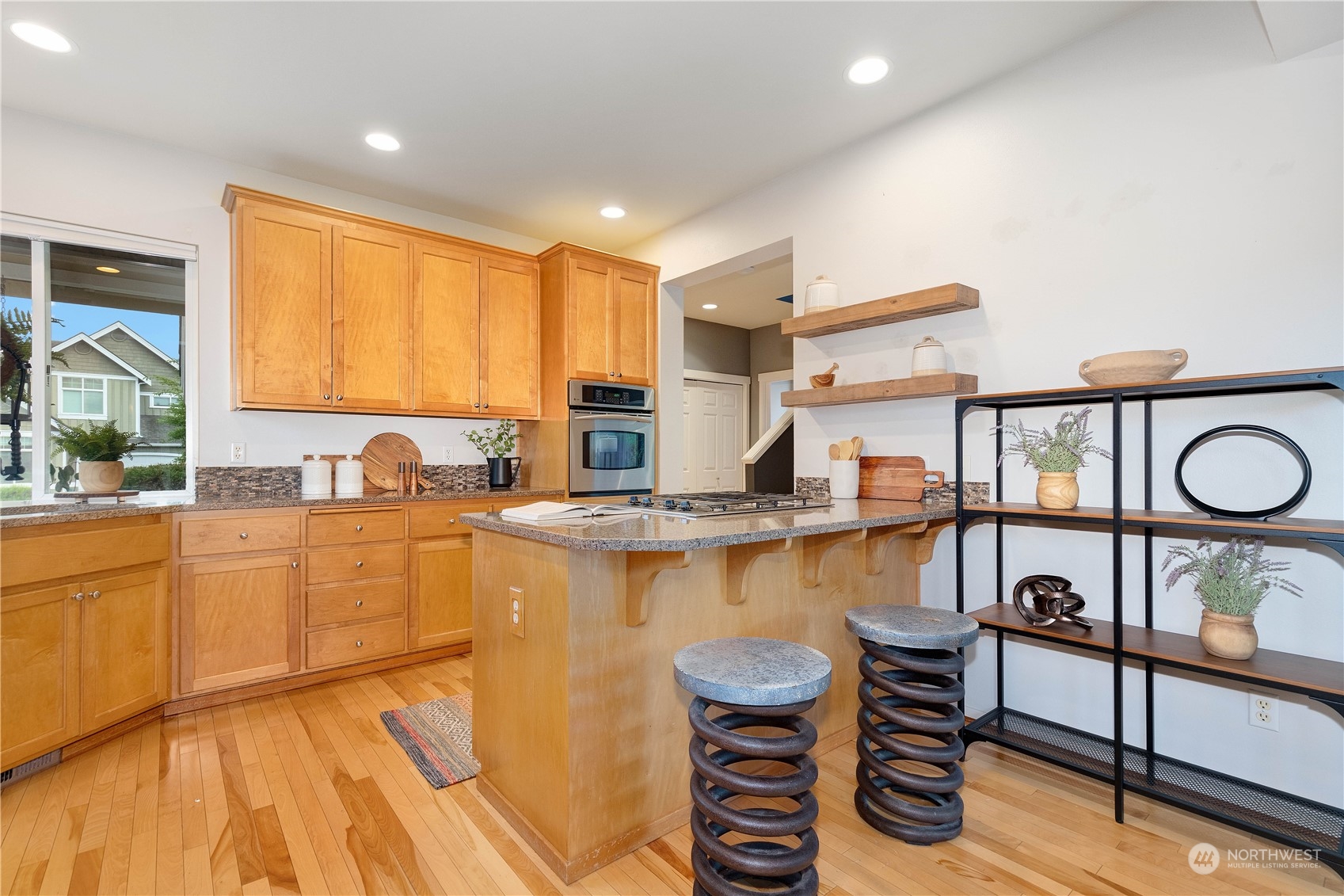 16722 166th Place Southeast Renton, WA 98058 - Photo 14 of 35 a kitchen with stainless steel appliances granite countertop a stove a sink and a refrigerator with wooden floor